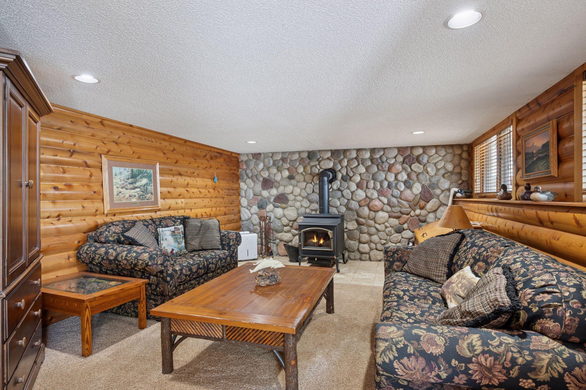 Basement Living Room with Wood Burning Stove, Natural Woodwork, and Stone Make this Room So Cozy!