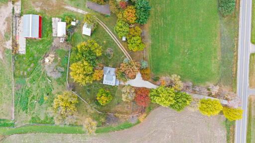 A bird's-eye view of the existing homesite and outbuildings, situated among mature trees with convenient access to the surrounding acreage