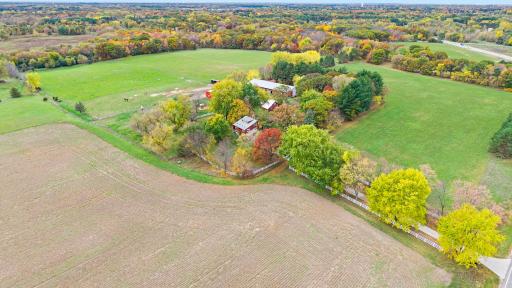The existing homesite is tucked among mature trees and includes a residence, multiple barns, and additional outbuildings