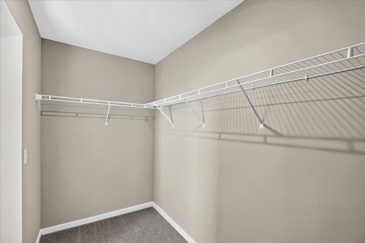PHOTO OF A DIFFERENT HOME WITH SIMILAR PLAN AND FINISHES. Primary Suite Walk-in Closet.