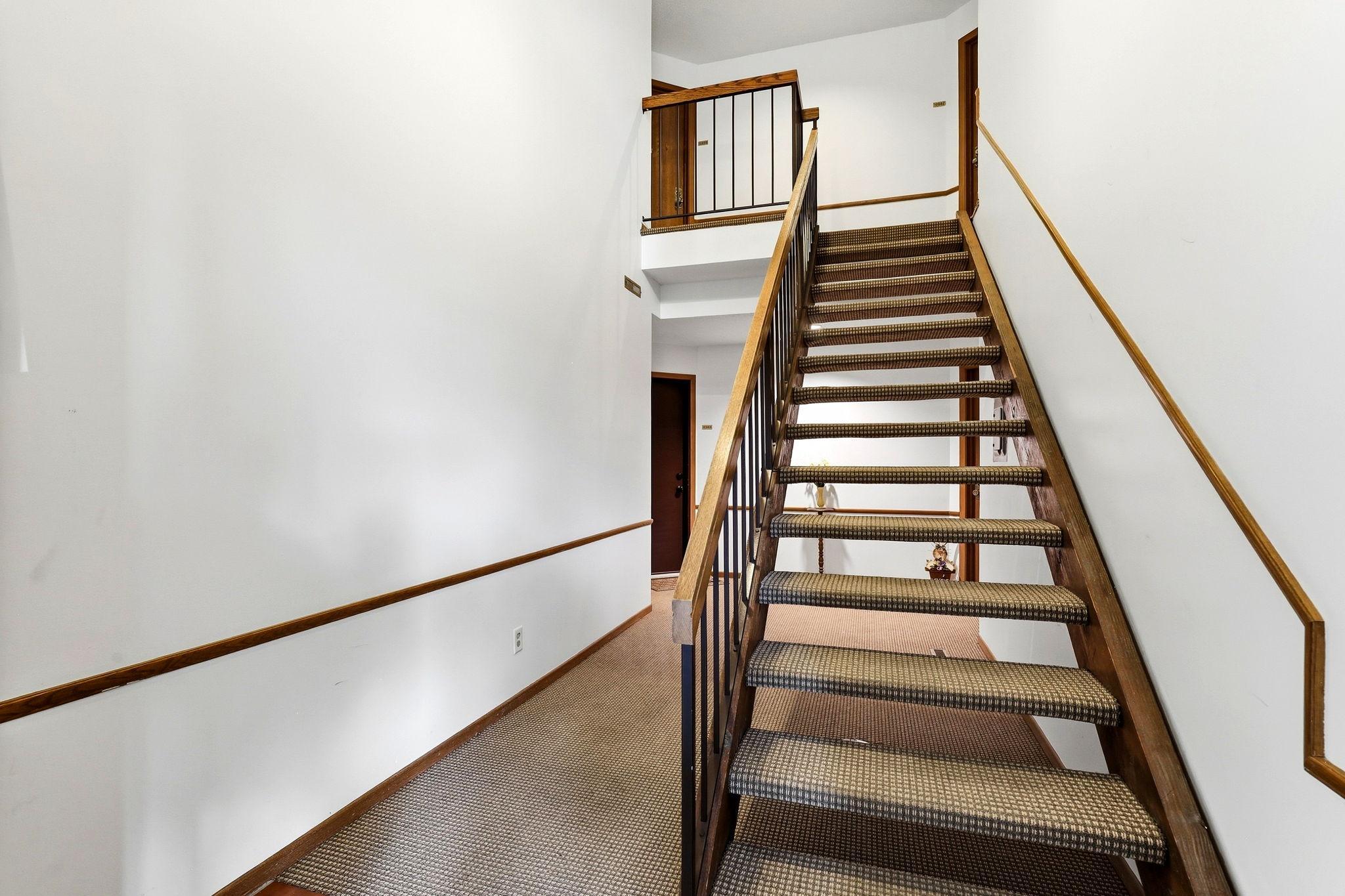 Interior common stairway leading to the upper-level unit, conveniently located at the top left.