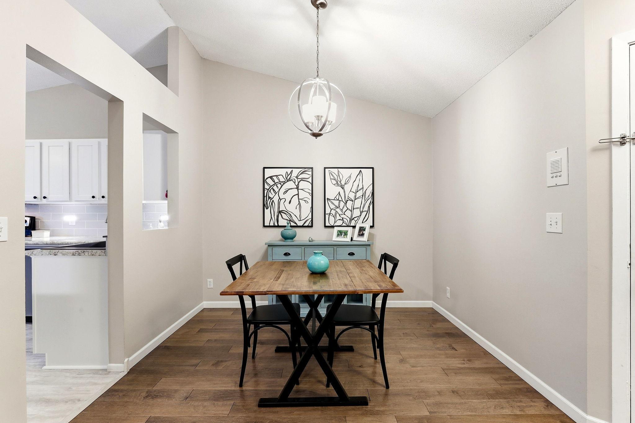 Inviting dining area with wood flooring, vaulted ceiling, modern pendant lighting, and an open connection to the kitchen and living spaces.