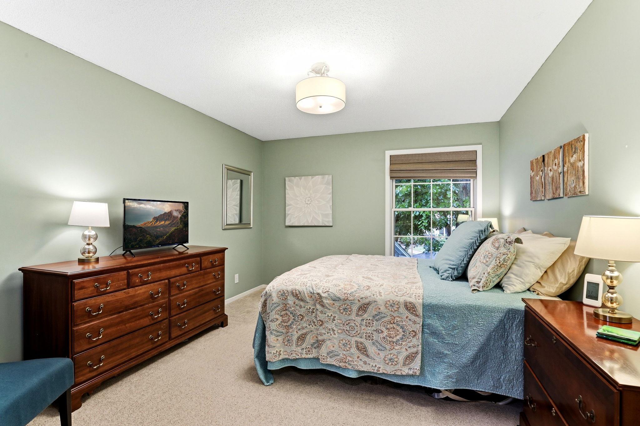 Spacious primary suite featuring a private full bath and walk-in closet, with a large window providing natural light.