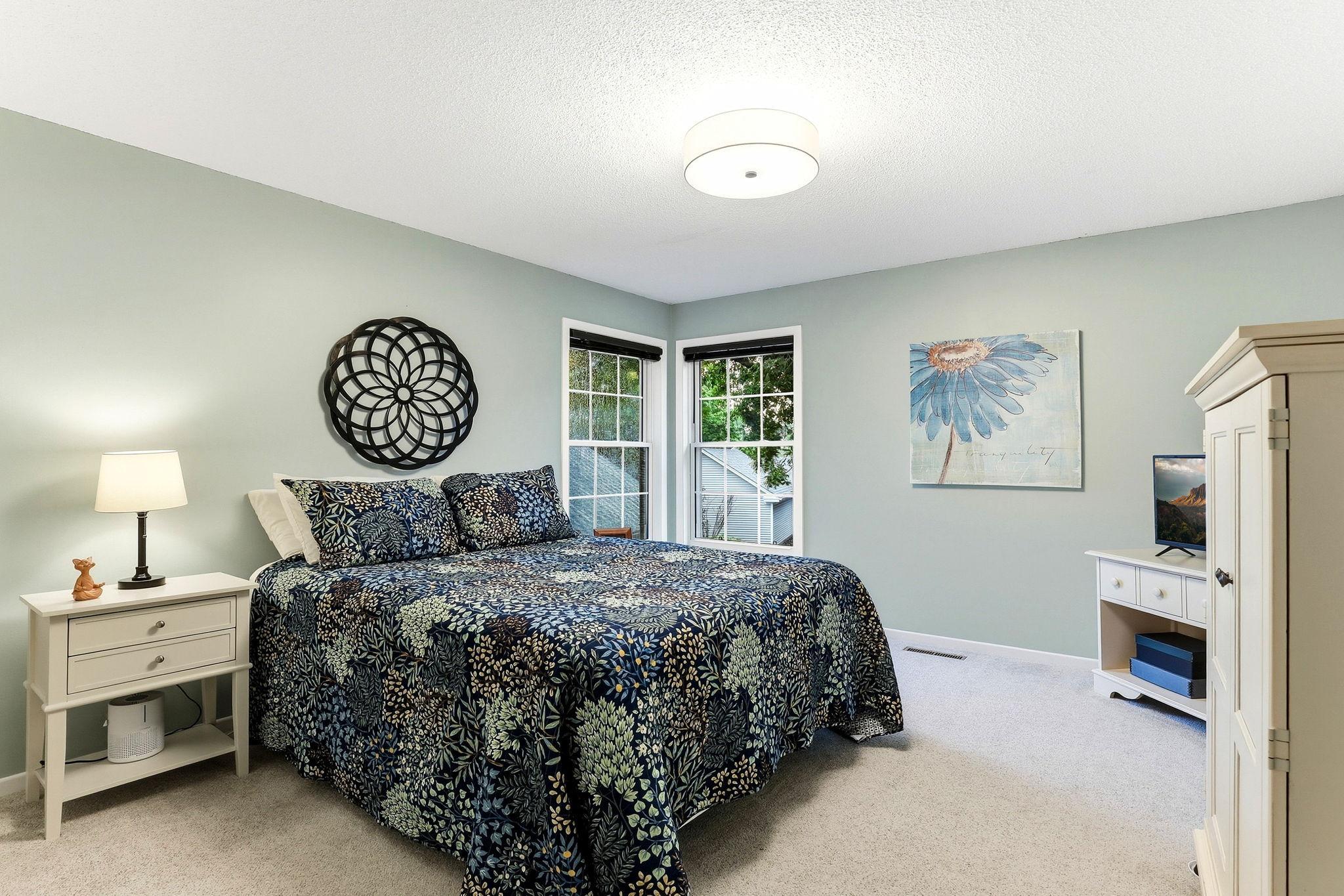Spacious second bedroom featuring soft carpeting, two windows for abundant natural light, and plenty of room for furnishings.