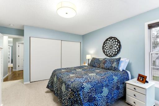 Another view of the spacious second bedroom featuring a large closet, soft carpeting, and abundant natural light.