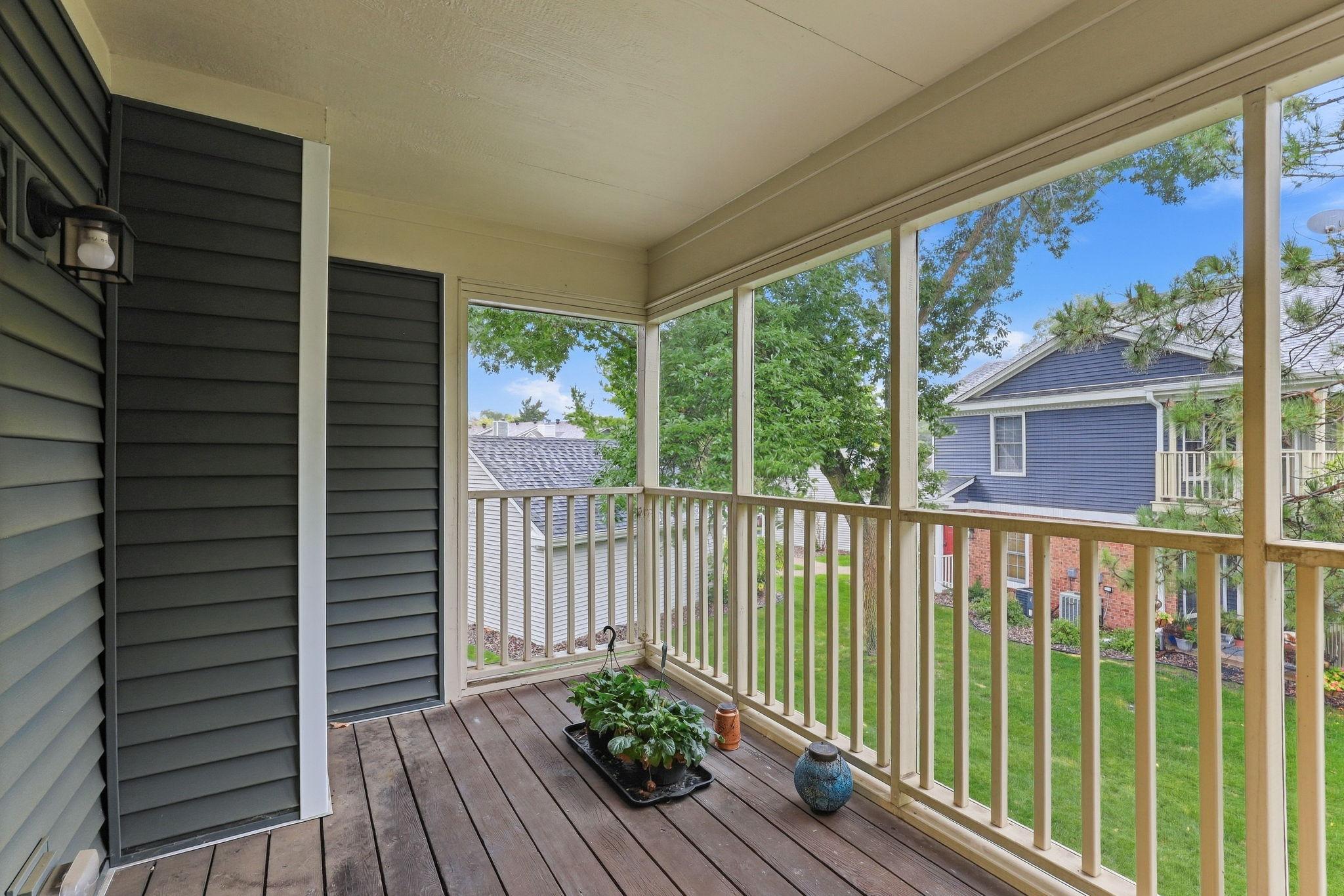 Private covered balcony featuring a durable, pet-friendly screen enclosure and peaceful views of the landscaped community.