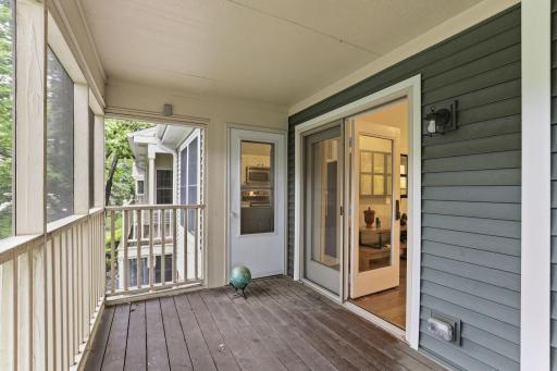 Another view of the private covered balcony featuring a durable screen enclosure and direct access to the living room.
