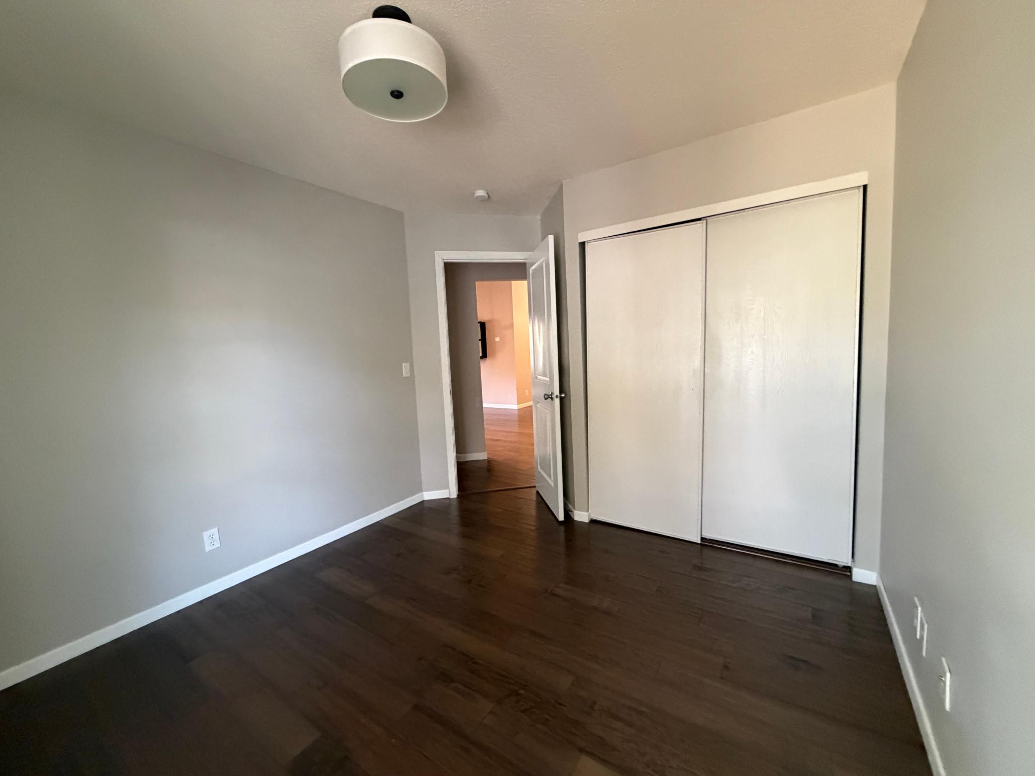 Spacious third bedroom featuring updated lightening and updated flooring.