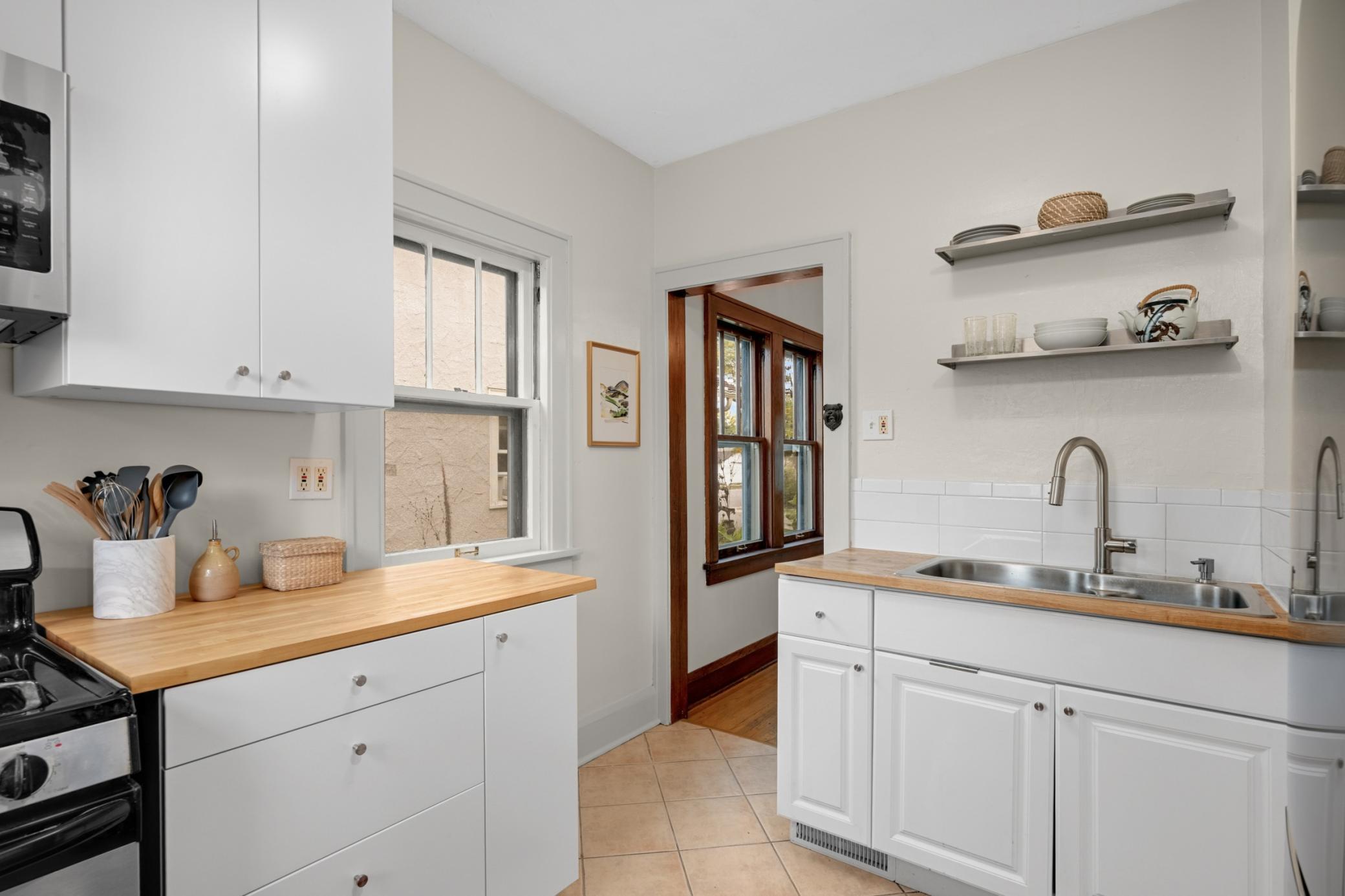 The bright kitchen has been updated with added cabinetry, butcher block countertops, and newer appliances.