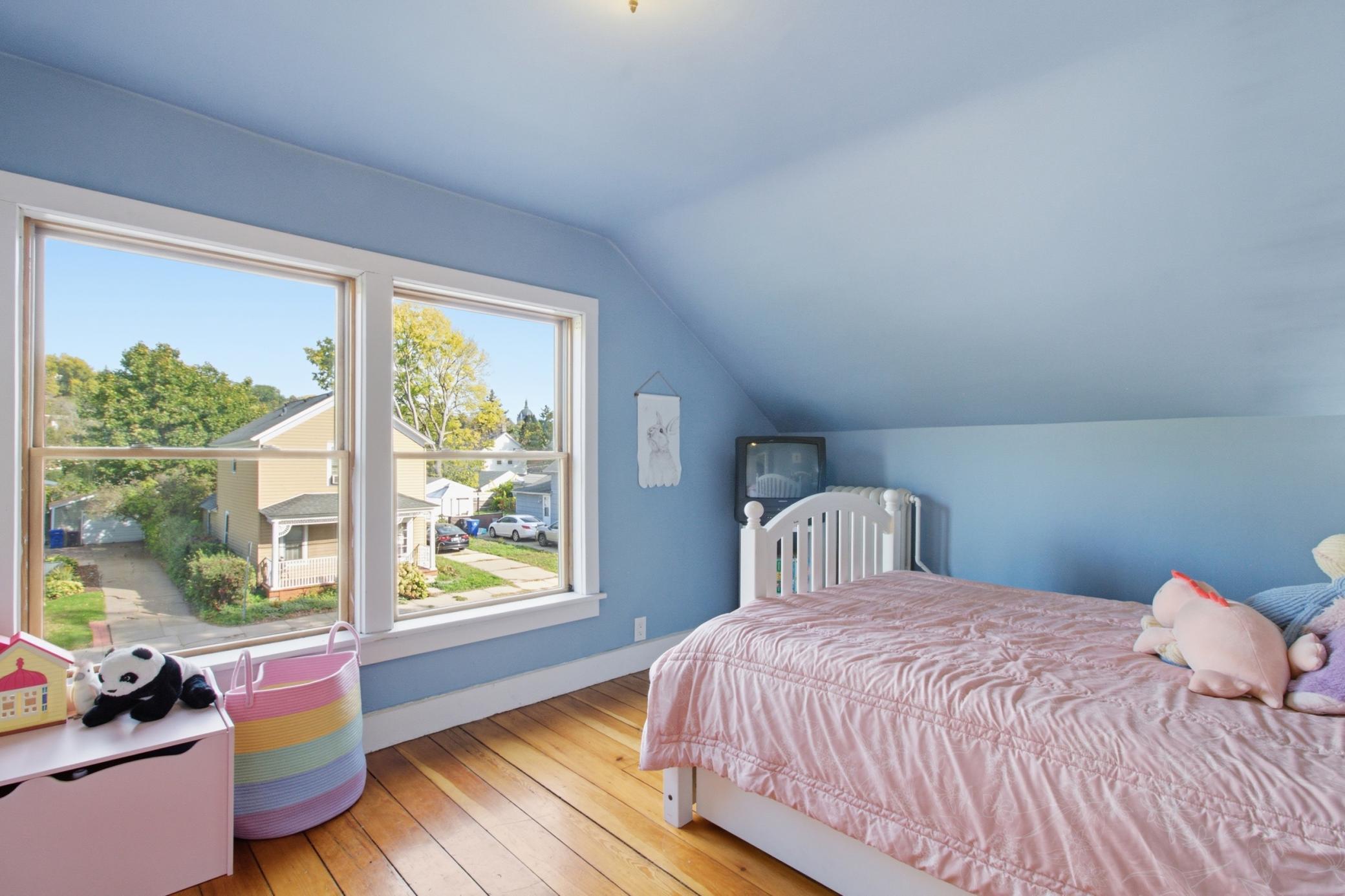 Upper level bedroom with a wall of windows.