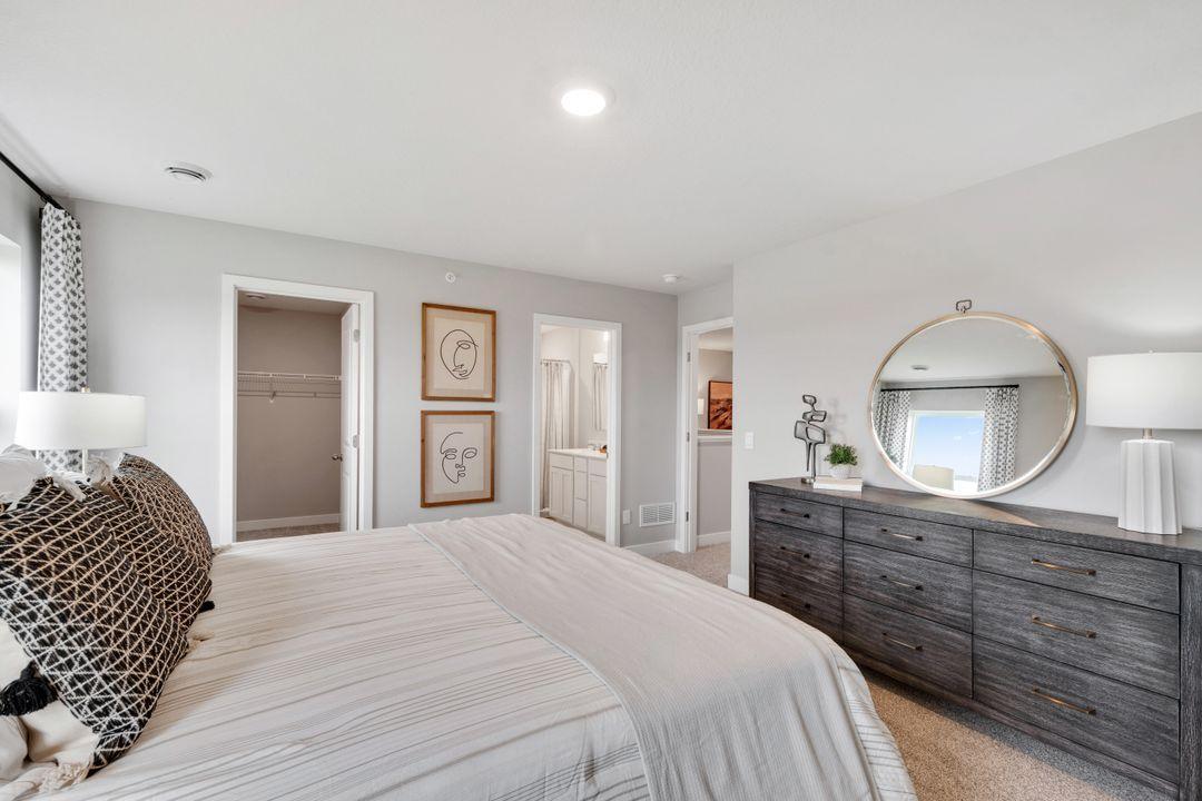 Spacious primary suite features large walk-in closet and bathroom. Photo of model home. Colors and finishes may vary.