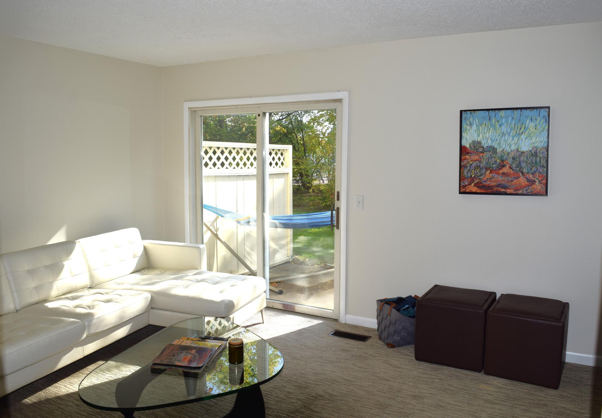 Unit 1 The living room has southern exposure and recieves great natural light through the sliding glass door that overlooks and walks out to the private patio!