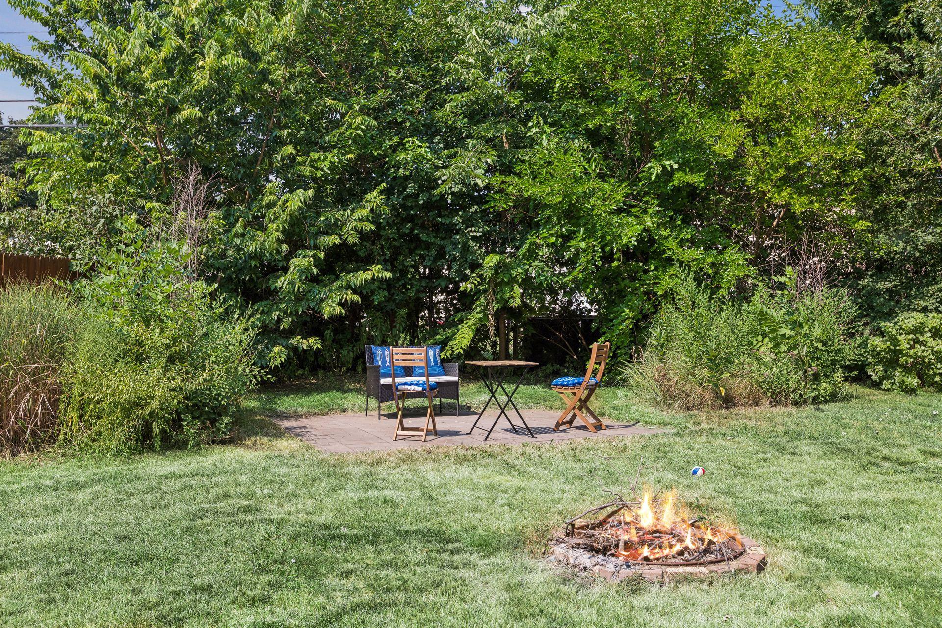 Patio area and fire pit at rear of the large back yard.