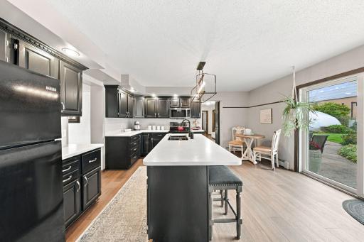 New LVP flooring flows throughout the main level, complementing the updated kitchen appliances, a spacious center island, room for a dining nook, and direct patio access.