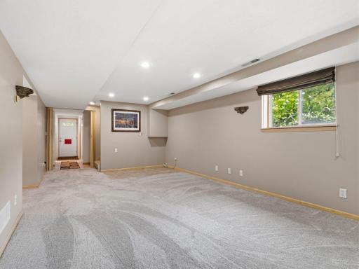 A private exterior entrance provides convenient access to the spacious lower level, offering a great setup for a home office or potential business use. The open layout, recessed lighting, and natural light create a comfortable and versatile space.