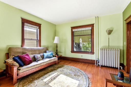 Living room features leaded glass window detail, abundance of natural light, and beautifully preserved woodwork
