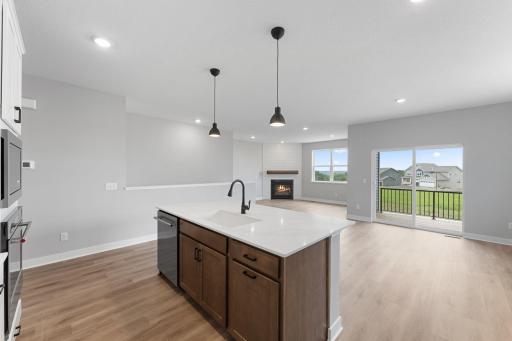 The kitchen offers open sight lines to the dinette, covered deck, and living room. Photo of actual home.
