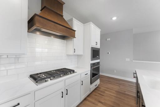 Entertain with ease with this 5 burner cooktop, hood vent, wall oven and microwave. Photo of actual home.