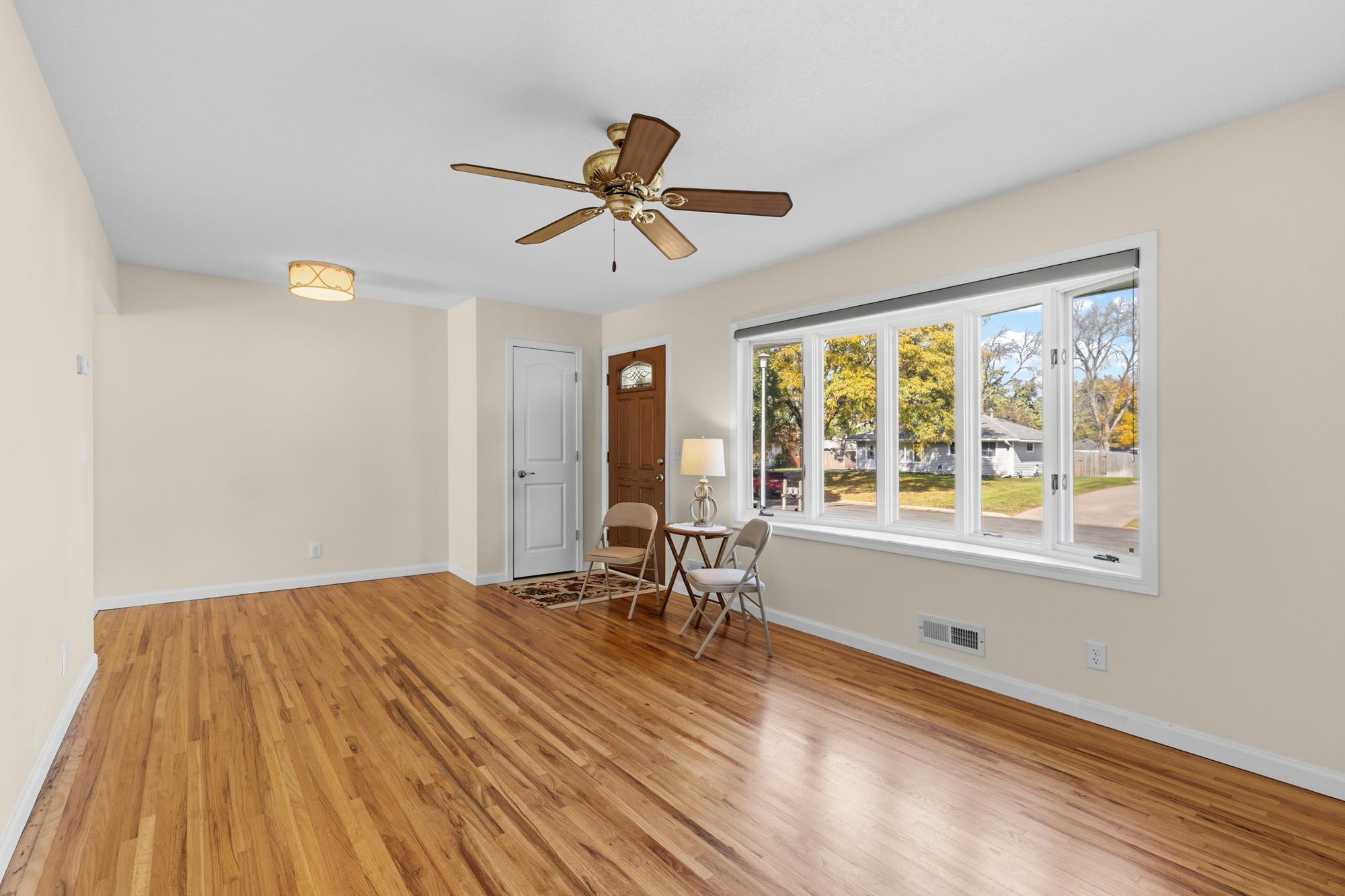 A look-back at the Living Room with its 5 window Bay, newer front door and coat closet.
