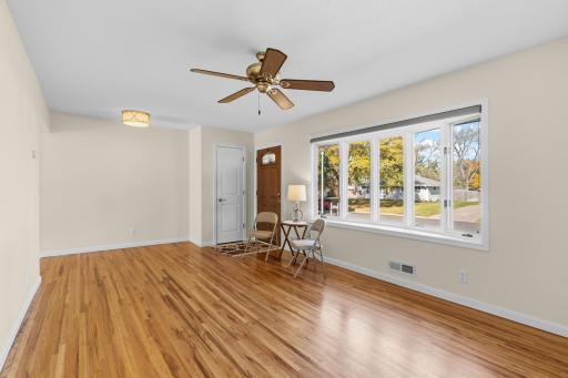 A look-back at the Living Room with its 5 window Bay, newer front door and coat closet.