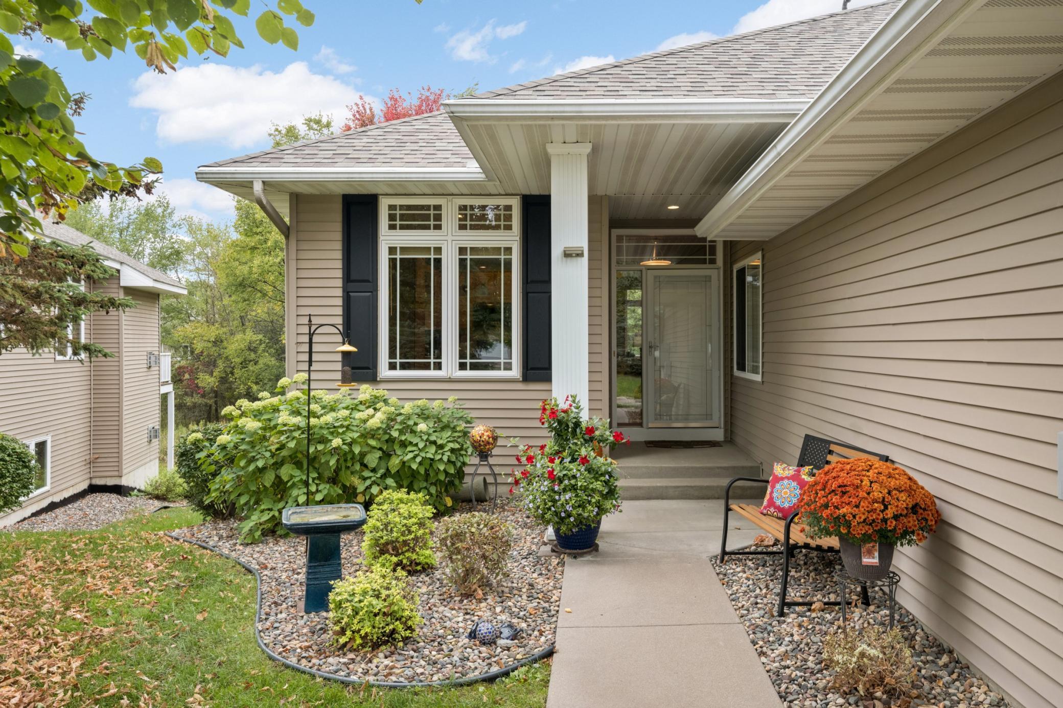 Welcoming covered front entrance with attractive landscaping and room for a bench to sit and enjoy the outdoors. The twin-home design means every home is an end unit!