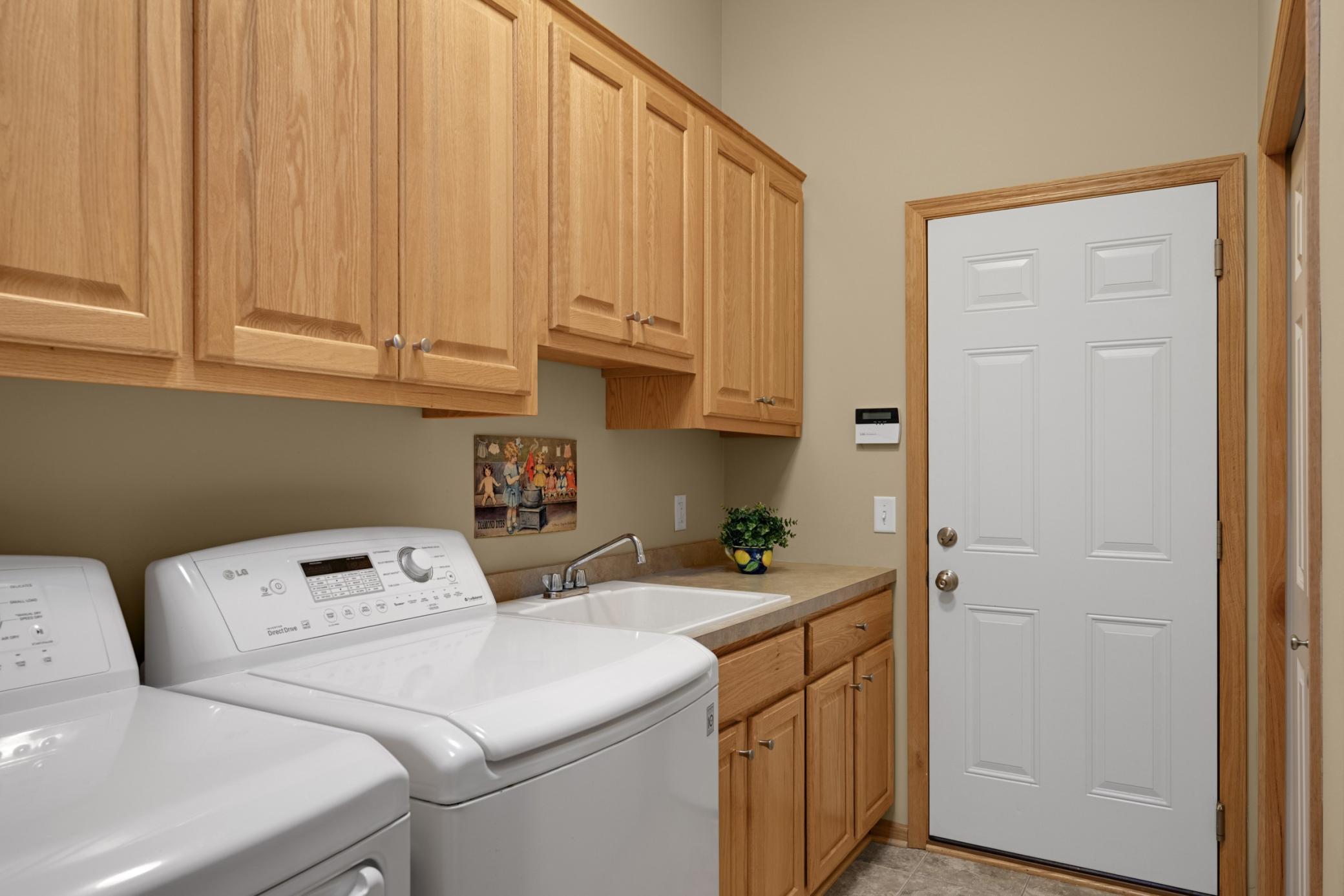 Convenient main-level Laundry Room located just off the Garage, with a utility sink, countertop workspace and numerous cabinets for storage. No need to carry laundry up and down the stairs!