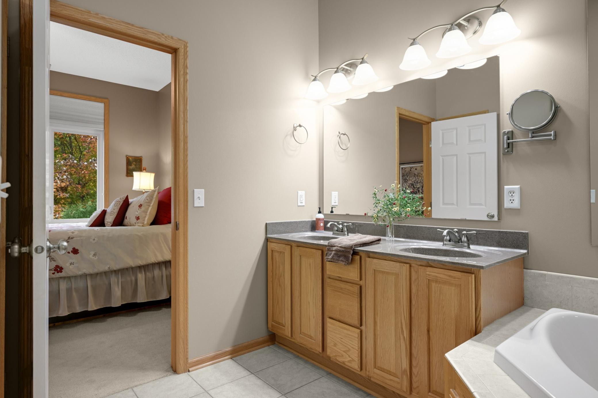 Spacious private Owner's Bath with double sinks, a large vanity, tile flooring and a separate jetted tub and shower. Plenty of counter space makes getting ready in the morning easier!