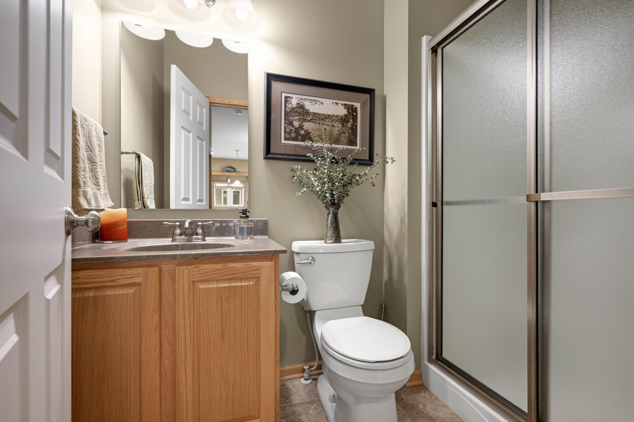 Additional main-level 3/4 Bath with a step-in shower, vanity and neutral finishes. Conveniently located for guests or those using the second main-level Bedroom as an Office.