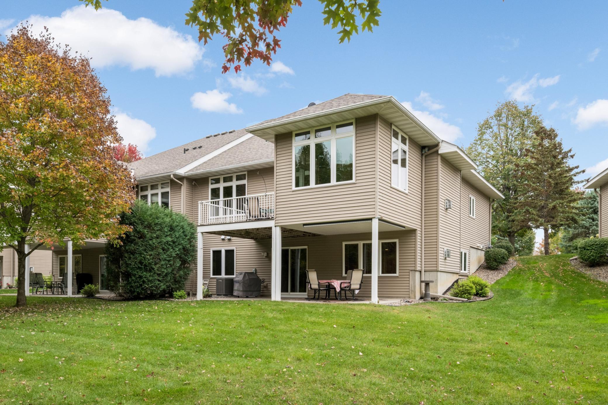 This view highlights the twin home's end-unit design, spacious lawn and outdoor living areas. Enjoy the convenience of townhome living without giving up the space of a larger home!