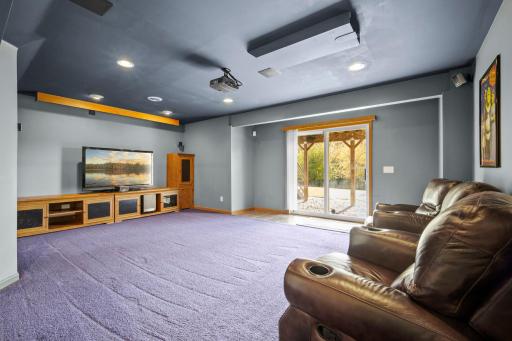 The lower level features a home theater with a 106-inch motorized screen, a Mitsubishi projector, Samsung surround-sound speakers, and a JBL bass speaker.