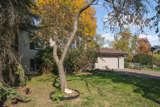 Mature trees and a generous front lawn add to the outdoor setting.