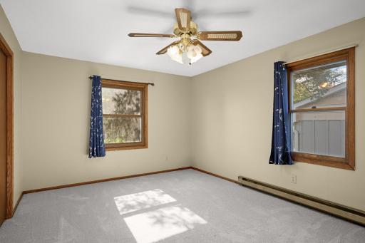 Upper-level bedroom with two windows, closet space and neutral carpeting.