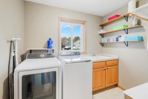 Main floor laundry with sink and cabinets is convenient to the kitchen. Window for fresh air is a bonus!