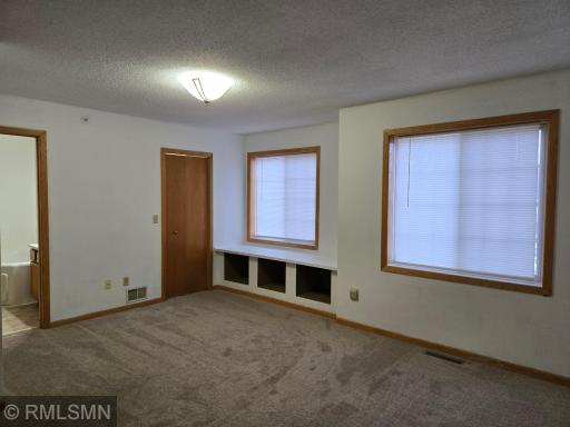 Primary Bedroom, full Bathroom, walk in closet, window seat with storage shelves underneath