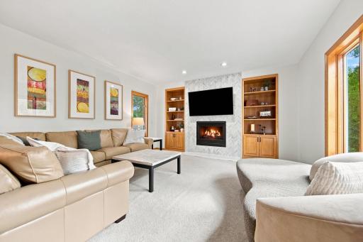 Living room featuring an eye-catching floor-to-ceiling tiled gas fireplace.