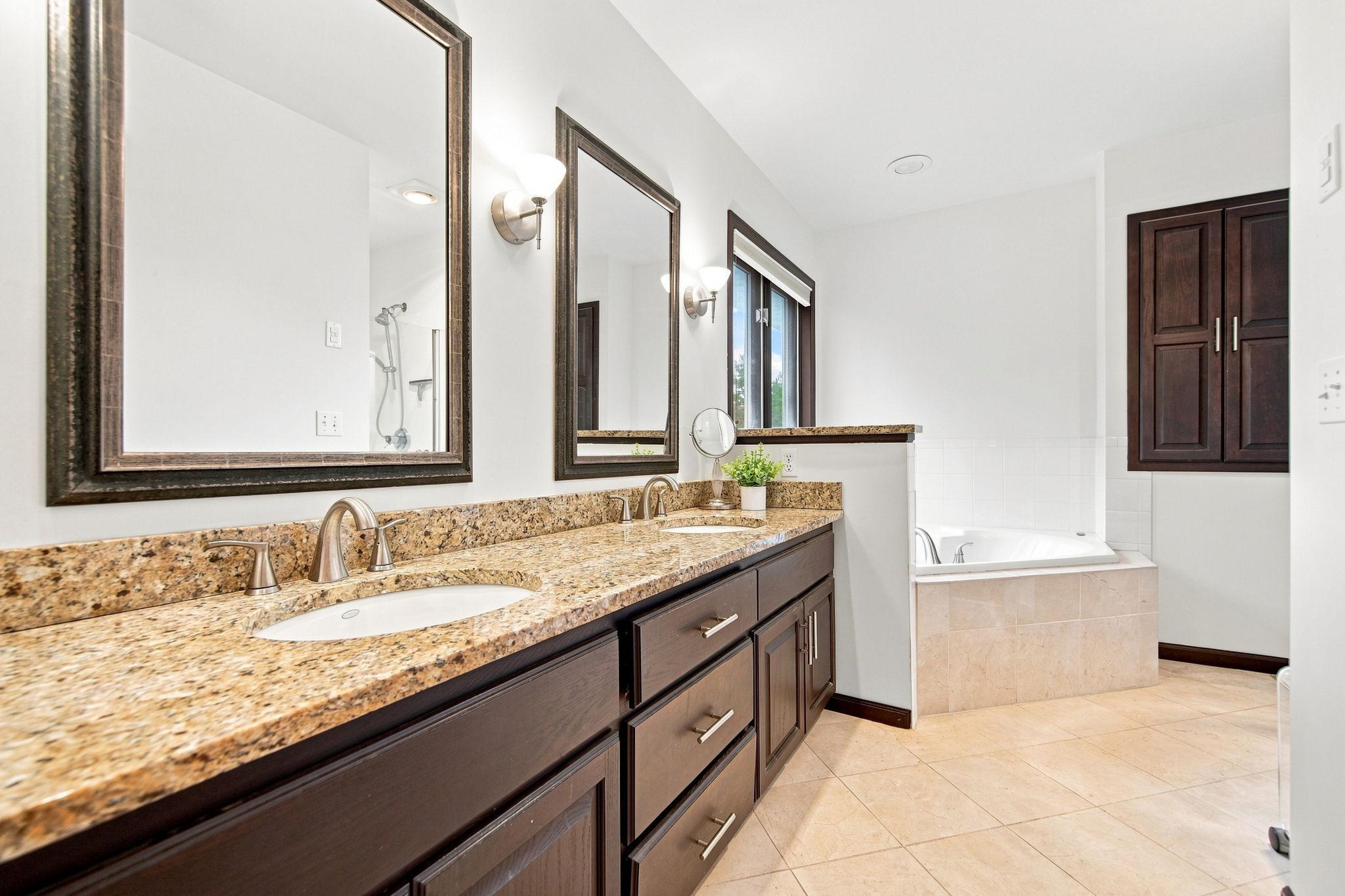 Private primary bath has also been freshly painted and featuring double sinks, a soaking tub, and separate shower.