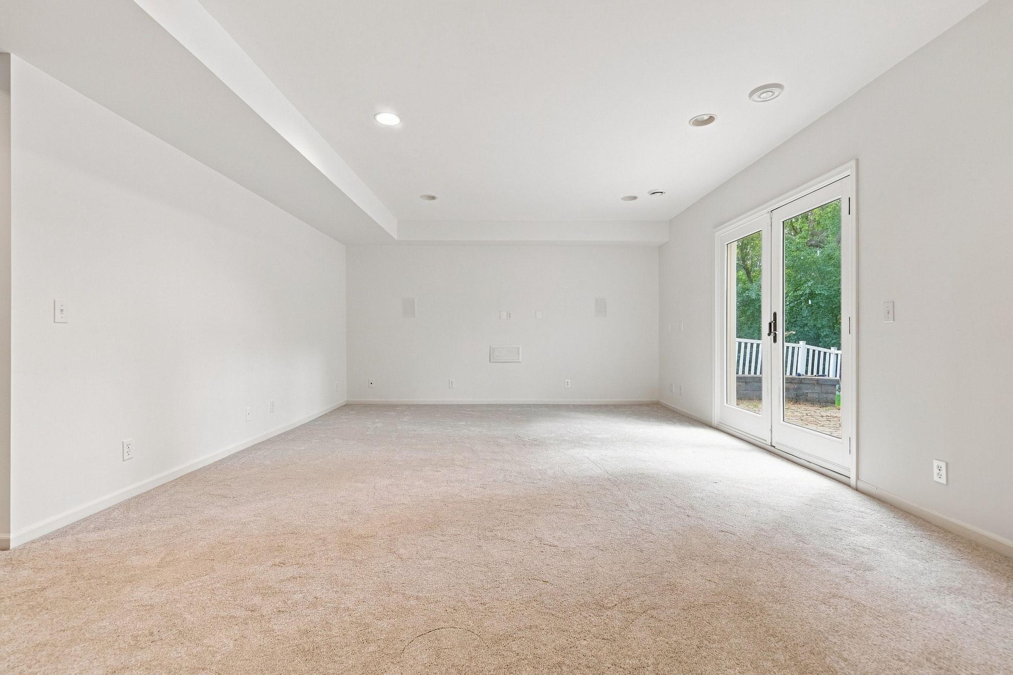 Walkout lower-level family room with a built-in surround sound system, perfect for movie nights and entertaining.