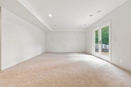 Walkout lower-level family room with a built-in surround sound system, perfect for movie nights and entertaining.
