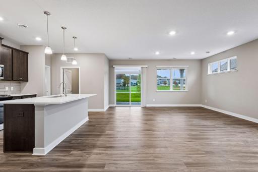 Large greatroom with kitchen, living room, and adjacent patio.