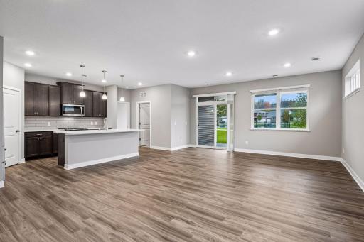Large greatroom with kitchen, living room, and adjacent patio.