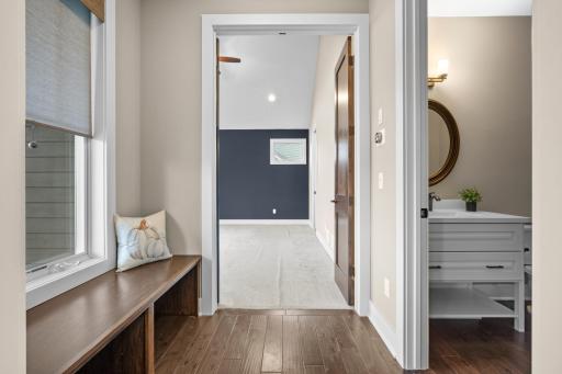 To the left of the entry is a large bench with under storage and a 1/2 bathroom. This is one entry into your primary suite as well.