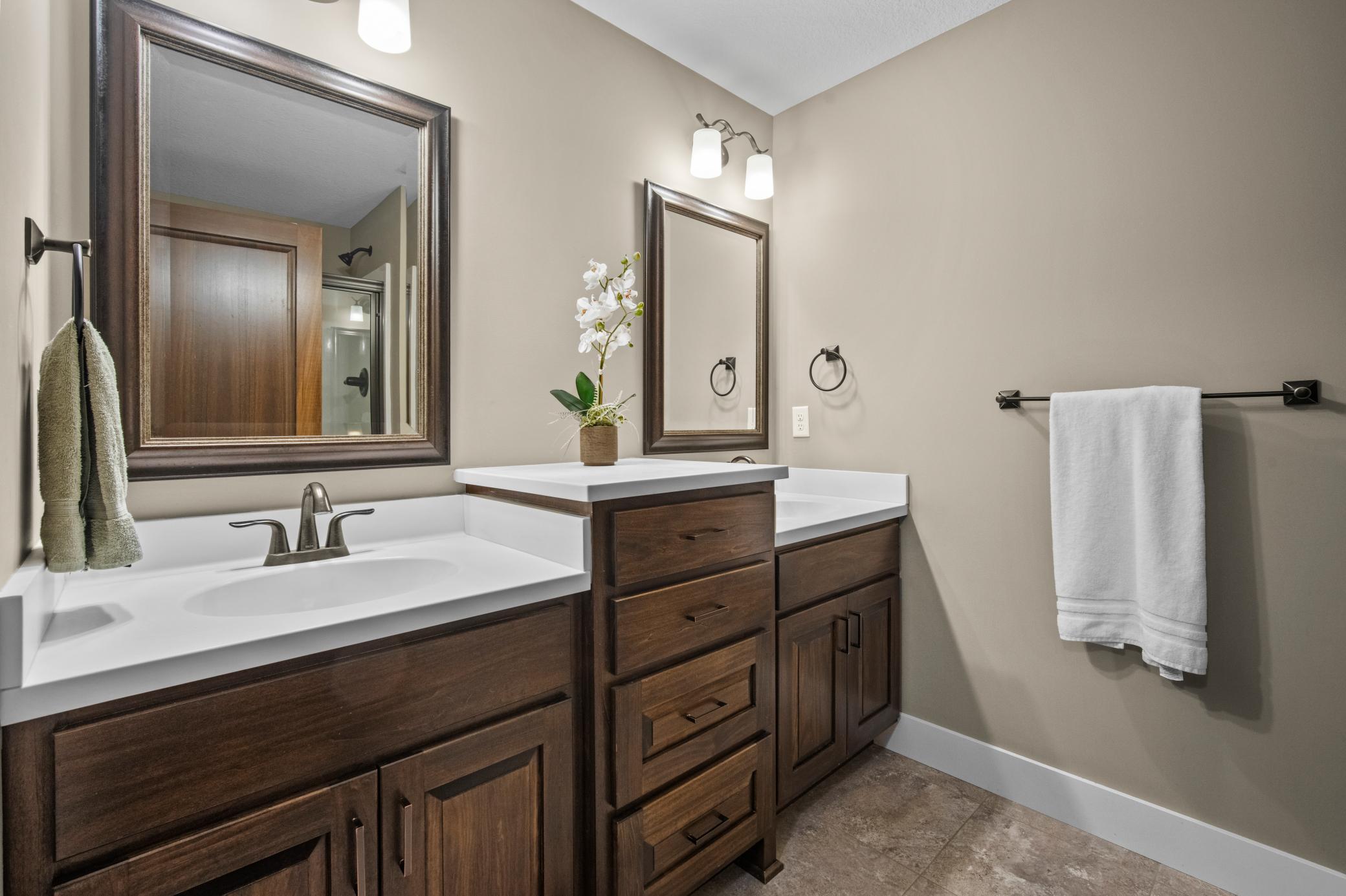 Lower level bathroom has 2 sinks and a tiled walk in shower