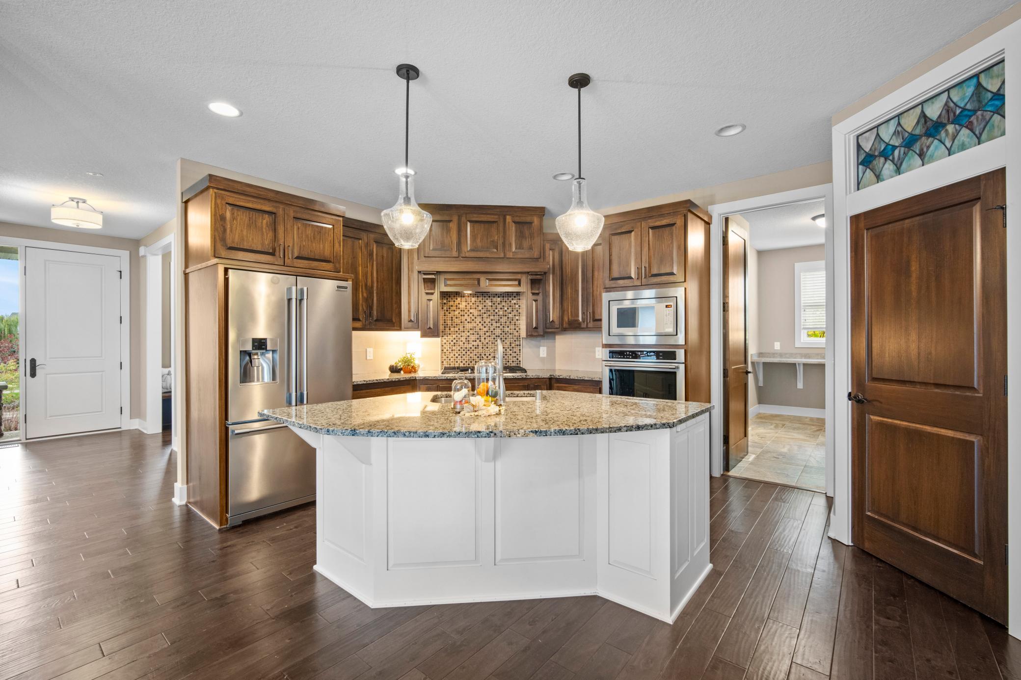 Island with sink. Walk in pantry is to the right in this picture