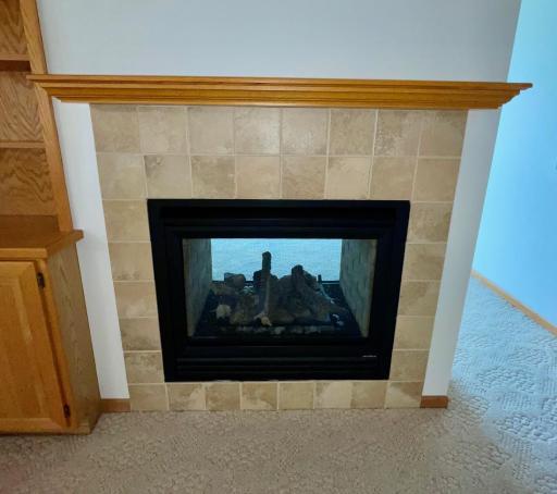 Fireplace serves both living room and den - has a thermostat for easy operation
