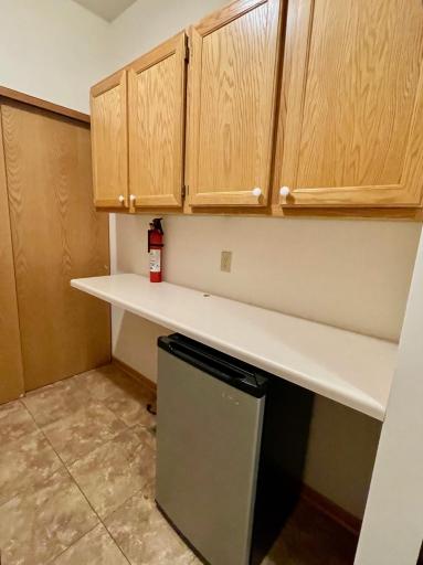 Laundry has extra cabinets, laundry folding area and mini-fridge