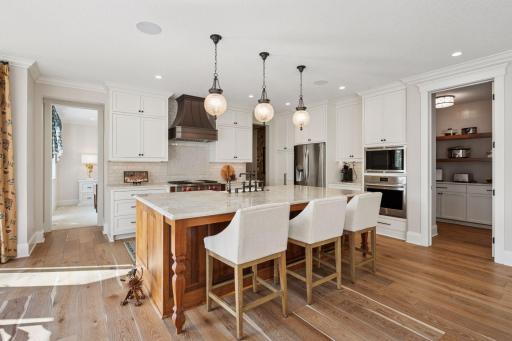 The kitchen is beautifully appointed with a large center island with Taj Mahal quartzite countertops.