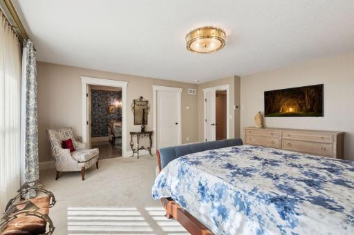 Spacious primary suite with 3/4 bathroom and walk-in closet.