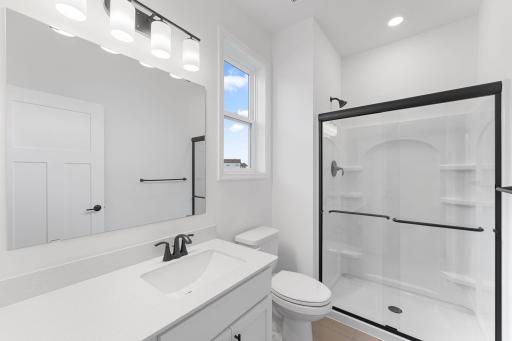 Bedroom 2 boasts access to a private bathroom with a single vanity and glass-enclosed shower