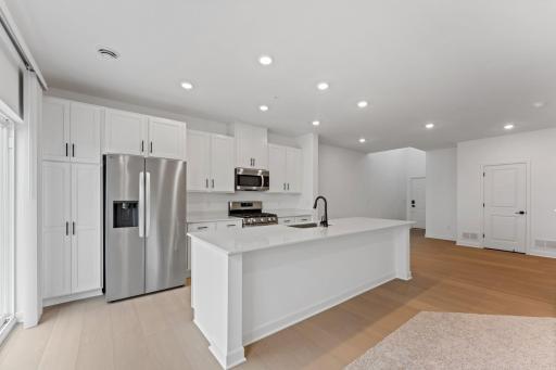 (Photo of a similar home, actual finishes may vary) At the focal point of this modern kitchen is a quartz-topped center island to add bar-style seating, and all-new stainless steel appliances to craft delicious meals.