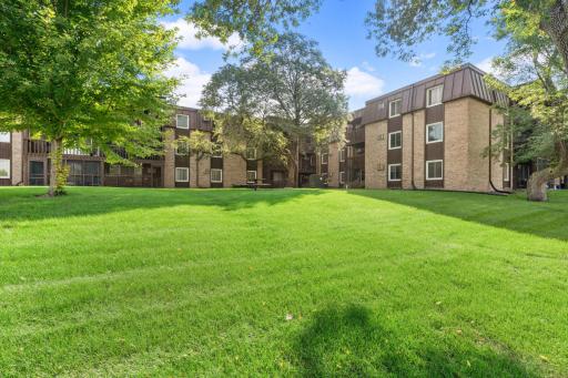 Beautifully landscaped grounds provide expansive green space, mature trees, and a peaceful park-like setting.